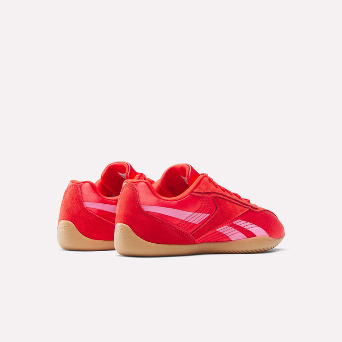 The Women's Ultra Lo Shoes by Reebok feature a bright red athletic design with white stripes and tan rubber soles, styled for sport. They are shown side by side on a plain white background.