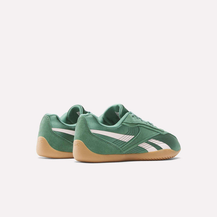 A pair of green Reebok Women's Ultra Lo Shoes with white stripes and tan gum soles are displayed on a plain white background, the left shoe slightly behind the right. These lightweight shoes blend style and comfort for everyday wear.