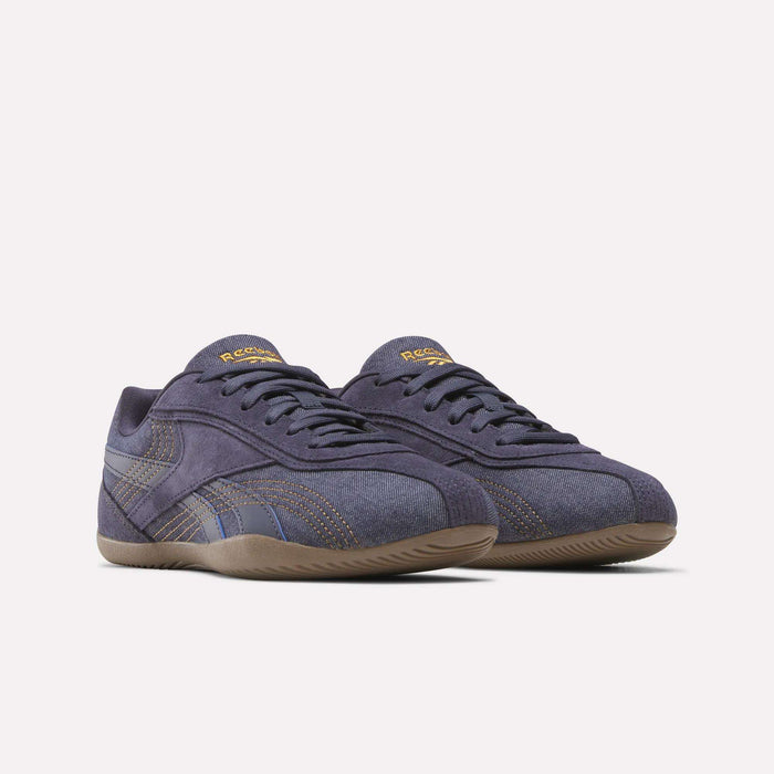 A pair of Reebok Women's Ultra Lo Shoes in dark blue, featuring brown stitching, gum soles, and a low-top design, displayed on a plain white background.