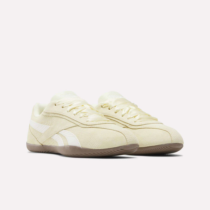 A pair of Women’s Ultra Lo Shoes by Reebok in beige, crafted with a suede upper, white side stripes, and gum soles, displayed against a plain white background.