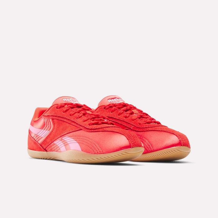 The Reebok Women's Ultra Lo Shoes feature a bright red design with pink side stripes and light brown rubber soles, offering effortless sport-inspired style in a low-profile silhouette—perfect for any look.