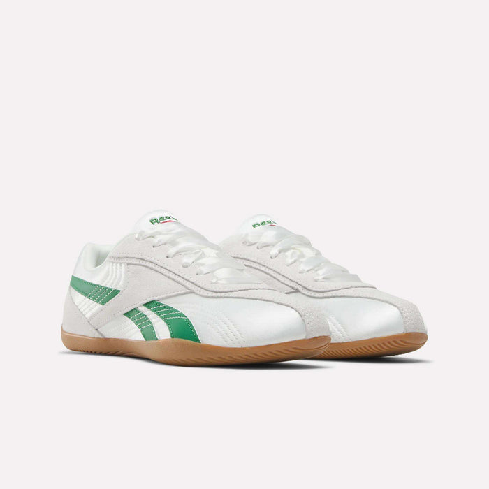The Women's Ultra Lo Shoes by Reebok are white sneakers with green stripes, green Reebok logos on the tongue, white laces, and gum rubber soles, shown against a plain white background.