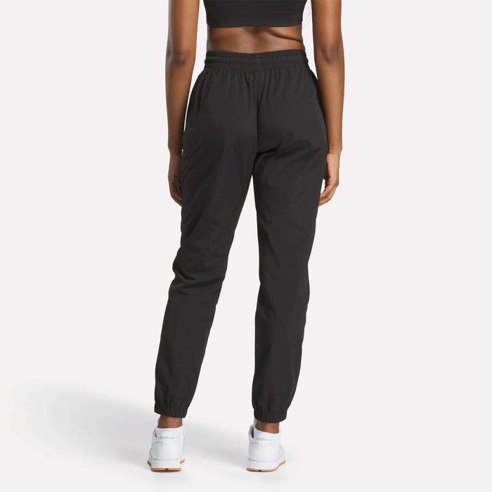 A woman wearing Reebok Women's Vector Track Pants.