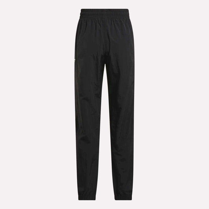 Women's Vector Track Pants by Reebok, shown in black on a plain light background. These feature an elastic waistband and cuffs, straight-leg fit, and lightweight shiny material for a retro-inspired look.