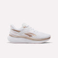 The Reebok Women's Viva Speed Shoes feature a white design with metallic rose gold accents and a thick, cushioned sole, displayed in a side profile against a plain white background.