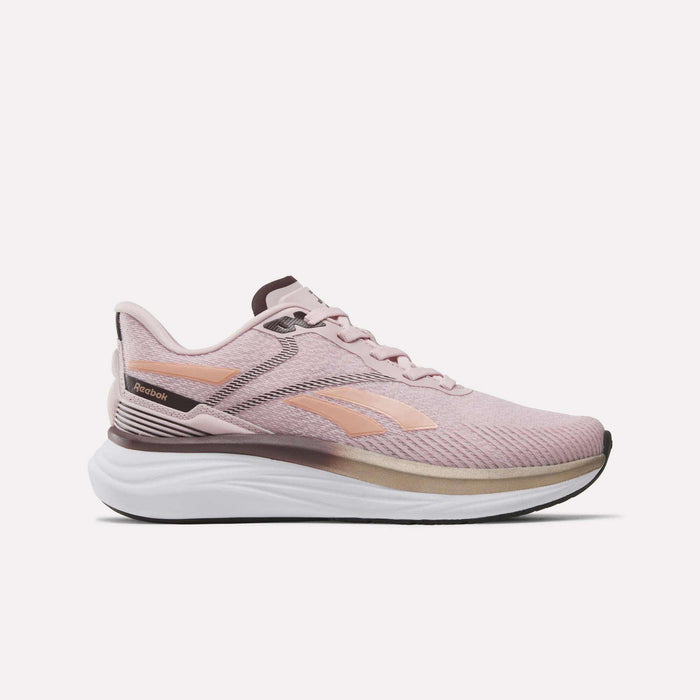 A women’s Reebok Viva Speed Shoe in Elemental Pink with Dark Cocoa and Rose Gold accents is shown in a side profile against a plain white background. Featuring a white sole and breathable mesh fabric, these cushioned running shoes deliver comfort and style for your daily workouts.