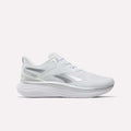 Introducing the Reebok Women’s Viva Speed Shoes—featuring a sleek white design with silver accents, a breathable mesh upper, and a thick cushioned sole for superior comfort and support. Photographed from the side against a plain white background, these athletic running shoes are an ideal choice for anyone seeking both style and performance.