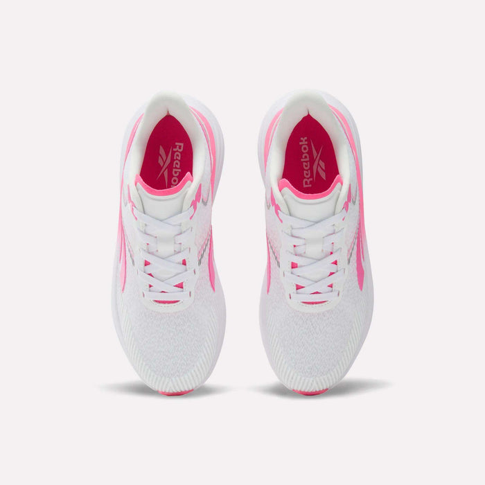 Top view of a pair of Reebok Women’s Viva Speed Shoes in white with pink accents, showcasing cushioned soles designed for all-day comfort. The image highlights the laces, interior logo, and textured soles. These breathable shoes are displayed side by side against a plain white background.