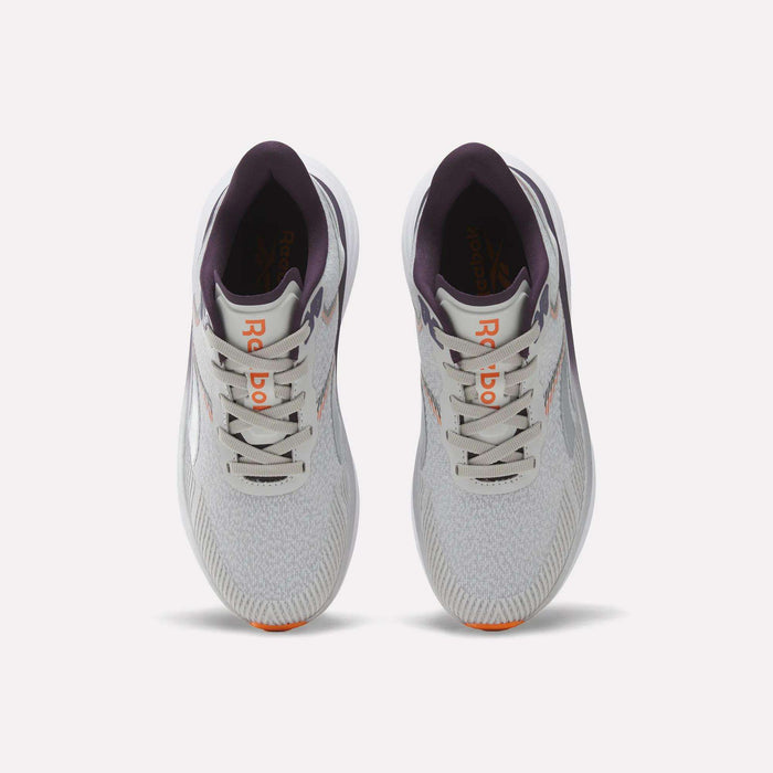 Top view of a pair of Reebok Women's Viva Speed Shoes in light gray with purple accents, featuring an orange logo on the tongue, white laces, and lightly patterned mesh uppers, placed side by side on a plain white background. These breathable running shoes offer a cushioned midsole for enhanced comfort with every stride.