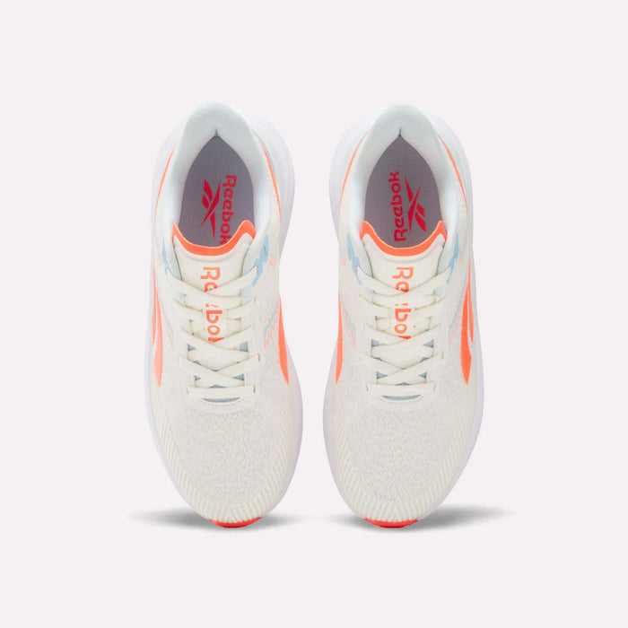 Top view of a pair of Women's Viva Speed Shoes by Reebok in white with orange accents and light blue details, displayed side by side on a plain white background. These breathable shoes feature the Reebok logo on the insoles for added style and comfort.