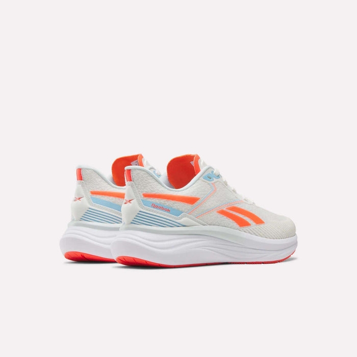 A pair of Women's Viva Speed Shoes by Reebok in white with orange and blue accents, featuring thick, cushioned white soles for comfort and breathability. The Reebok logo is displayed on the side and heel, set against a plain light background.