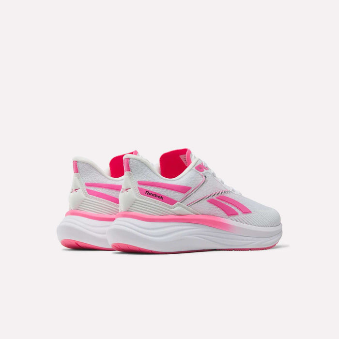 A pair of Women’s Viva Speed Shoes by Reebok, featuring a white design with bright pink accents and thick, cushioned soles, are shown from the back and side on a plain light background.