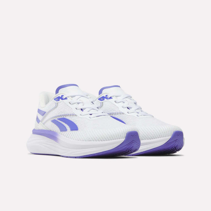 Introducing the Reebok Women's Viva Speed Shoes: a stylish pair of white athletic sneakers highlighted with vibrant purple accents on the sole, logo, and detailing. Featuring a cushioned design and breathable mesh texture for enhanced comfort, these sneakers are ideal for your active lifestyle. Shown here against a plain white background.