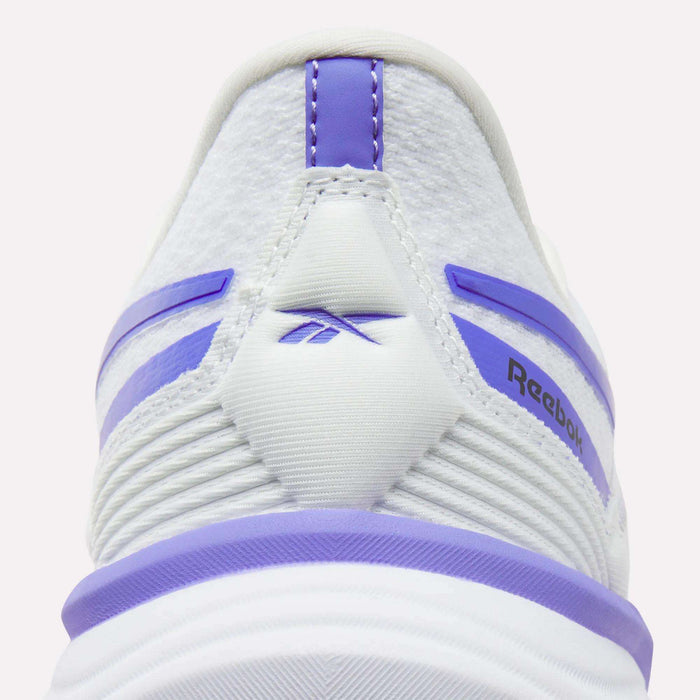 Close-up of the back of a white Women's Viva Speed Shoe by Reebok, showcasing purple accents along with the Reebok logo and stripe details. These cushioned sneakers are crafted for comfort and style.