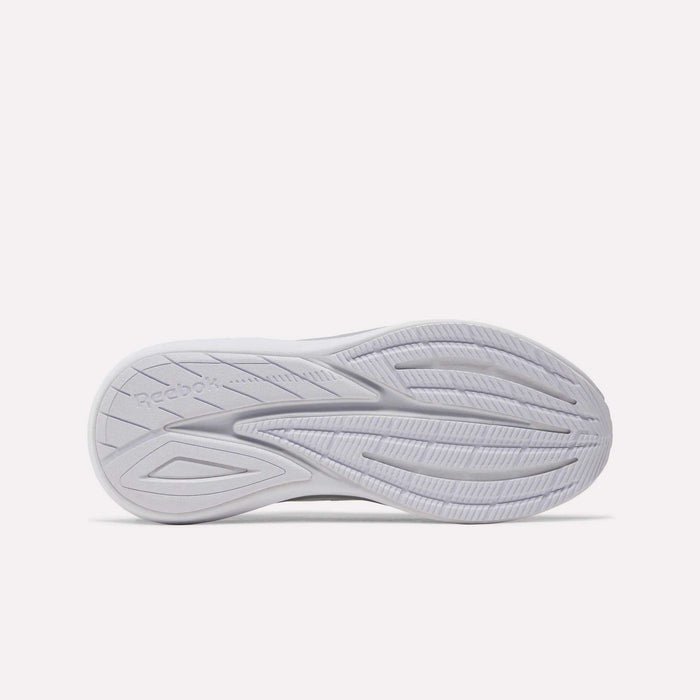 The image shows the white outsole of the Reebok Women’s Viva Speed Shoes, featuring curved grooves for traction and the Reebok logo embossed on the left side. Designed for comfort, these cushioned athletic shoes provide excellent support with every step.