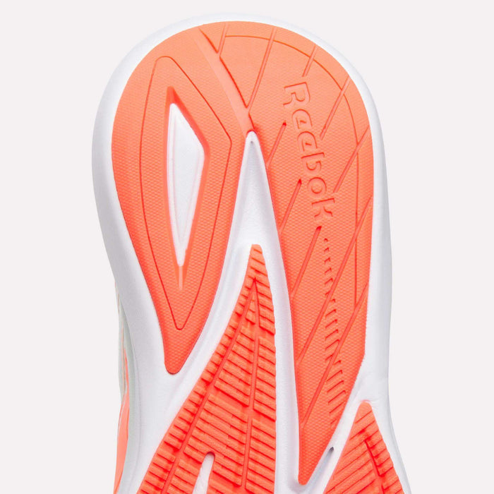 Close-up of the sole of a women's Reebok Viva Speed Shoe with bright orange and white geometric tread patterns and the Reebok logo embossed in the center, highlighting the design of these cushioned shoes.