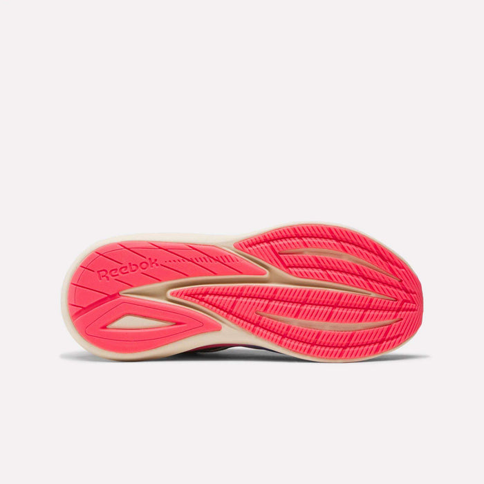 The image shows the sole of Reebok Women's Viva Speed Shoes, featuring a beige and bright pink color pattern, textured tread for grip, extra cushioning for comfort, and the Reebok logo embossed on the left side.