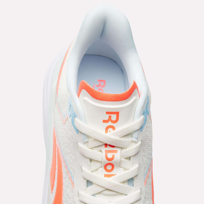 The Women's Viva Speed Shoes by Reebok feature a white athletic design with vibrant orange and blue accents, complemented by white laces and "Reebok" in orange on the tongue. Shown from above against a light background, these sneakers highlight their stylish look and breathable construction for all-day comfort.