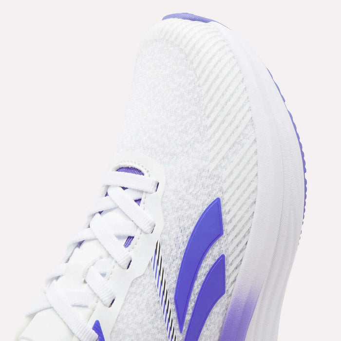 Close-up of the Reebok Women's Viva Speed Shoes, a white athletic shoe with purple accents, including signature purple stripes and a matching purple sole. This shoe features white laces, a textured upper fabric, and an EVA midsole for added comfort.