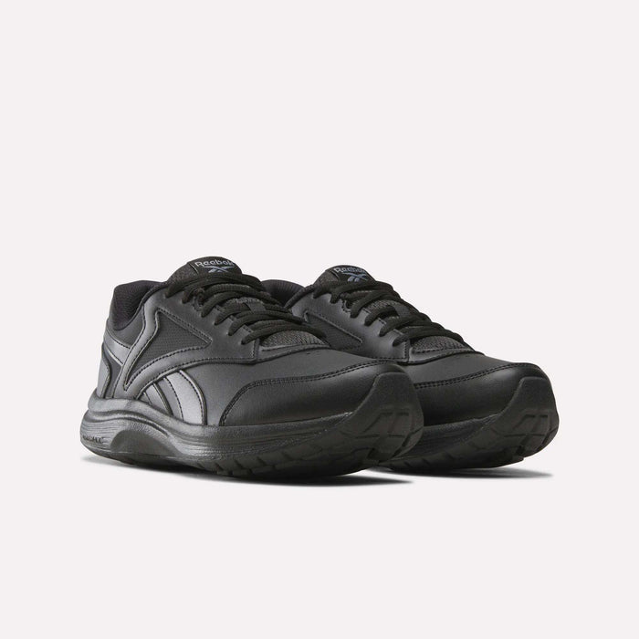 A pair of Reebok Women’s Walk Ultra 7 DMX Max Shoes in a wide D fit, featuring black athletic design with matching black laces and textured rubber soles for all-day walking comfort, displayed on a plain light background.