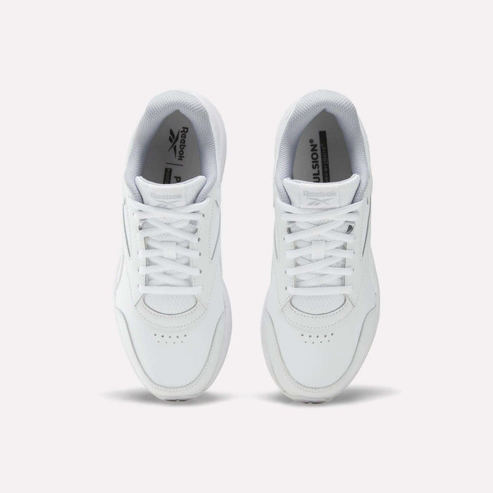Top view of a pair of Reebok Women’s Walk Ultra 7 DMX Max shoes in white, featuring laces, perforated toe areas, and visible Reebok logos on the tongues. These cushioned walking shoes are placed side by side on a light background and are designed for all-day comfort.