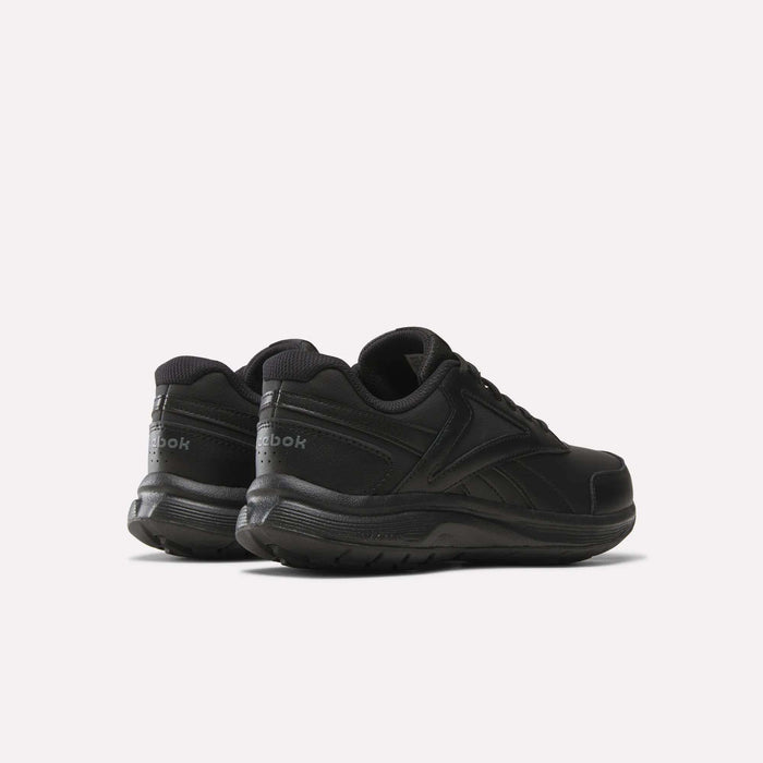 A pair of Women’s Walk Ultra 7 DMX Max Shoes by Reebok, shown from the back and side, featuring a black low-top design with a lace-up closure and subtle Reebok branding on the heel and side. Designed as cushioned walking shoes for all-day comfort, they are positioned on a plain white background.