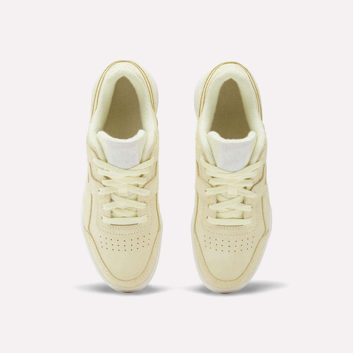 A pair of Women’s Workout Plus Shoes by Reebok in cream, seen from above with laces, perforated toes, and white tongue labels—classic ’80s fitness style set on a plain white background.