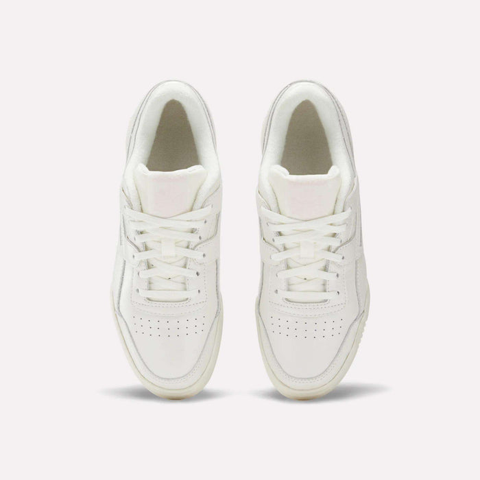 The Reebok Women's Workout Plus Shoes in white are shown from above, highlighting laces, stitching, and perforated toe boxes for classic '80s fitness style against a plain light background.