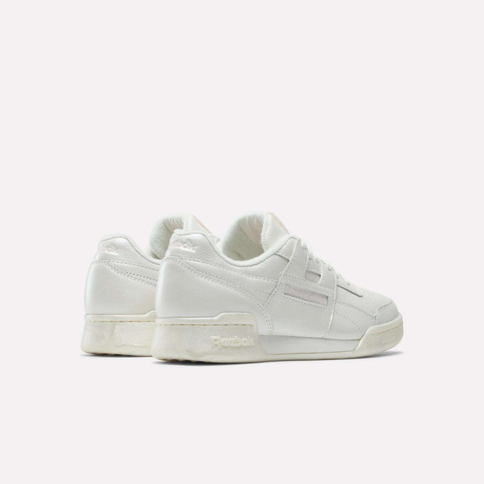 Two white Reebok Women's Workout Plus Shoes are shown angled from the back and side against a plain background, showcasing their simple 80s-inspired design and classic logo details.