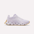 The Reebok Women's Zig Dynamica STR Shoes are light purple athletic sneakers with a breathable mesh upper, jagged EVA-cushioned midsole, and light brown rubber outsole, shown in side profile on a plain white background.