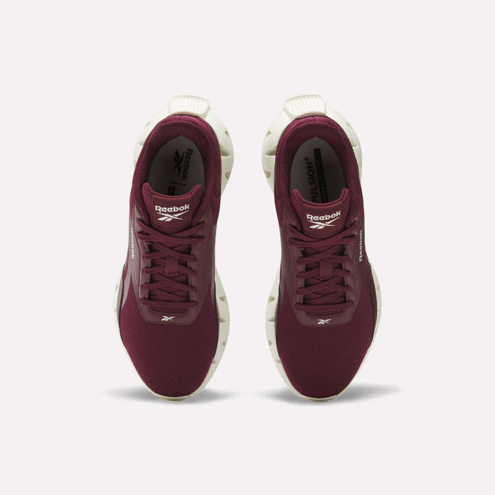 A pair of maroon Reebok Women's Zig Dynamica STR Shoes with white soles, seen from above on a white background. The breathable mesh upper and Reebok logos are visible on the tongue and side of each shoe.