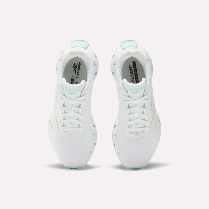 A pair of Reebok Women's Zig Dynamica STR Shoes in white with mint green accents, featuring breathable mesh for comfort, shown from above on a plain white background.