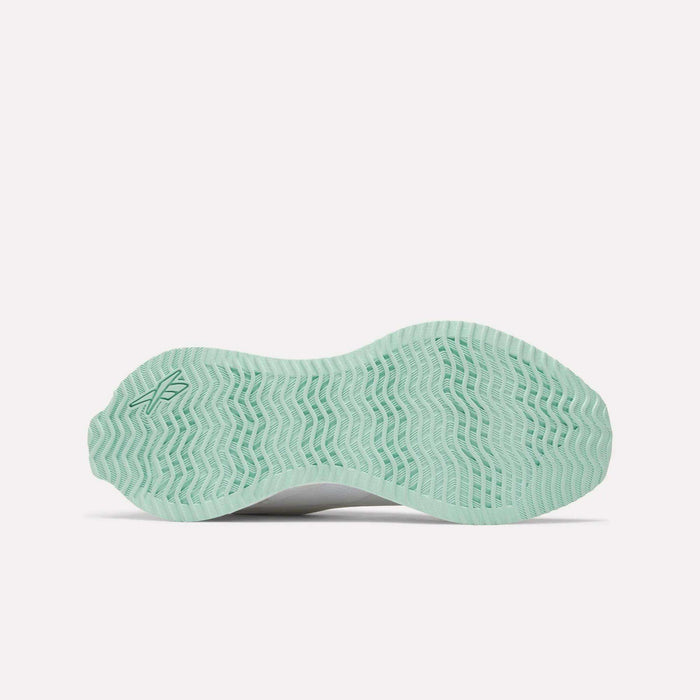 The Reebok Women's Zig Dynamica STR Shoes feature a light green outsole with a wavy, herringbone pattern, designed for innovation in running, displayed against a white background.