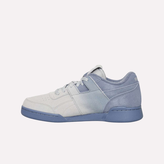 A low-top sneaker with a light gray front and a blue heel, blue sole, and matching blue laces, shown from the side on a plain white background. Featuring a classic silhouette inspired by retro sneakers, the Reebok Workout Plus Og Shoes are a timeless addition to any collection.