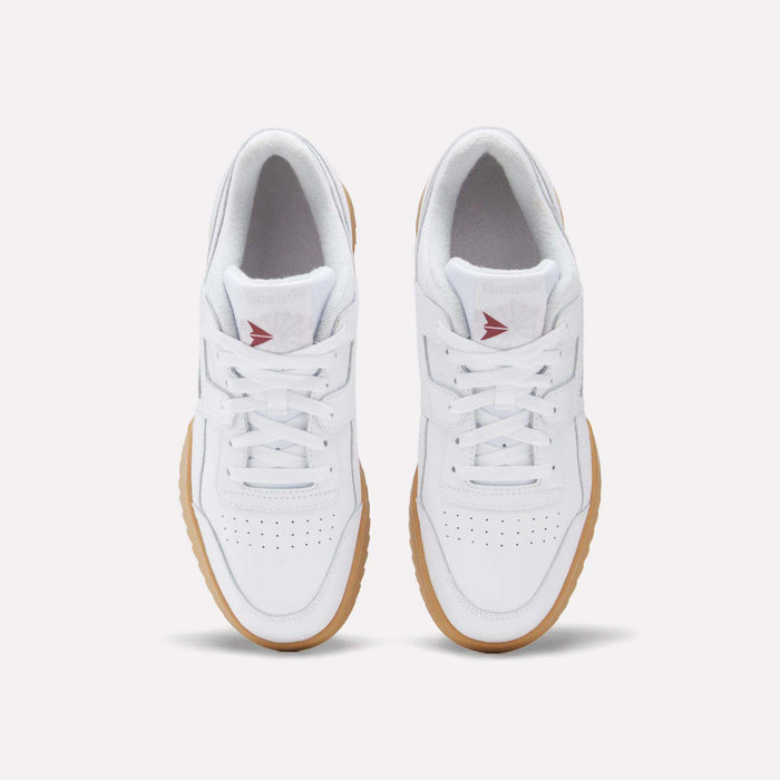 A top view of Reebok Workout Plus Ripple Shoes in white leather with gum soles, white laces, perforated toe boxes, and red Reebok logos on the tongues adds a subtle vintage touch.