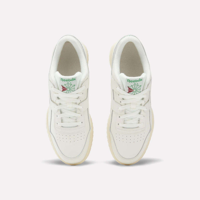 A pair of Reebok Workout Plus Ripple Shoes viewed from above, featuring green Reebok logos with a red and green design on the tongue, white laces, and cream-colored soles.