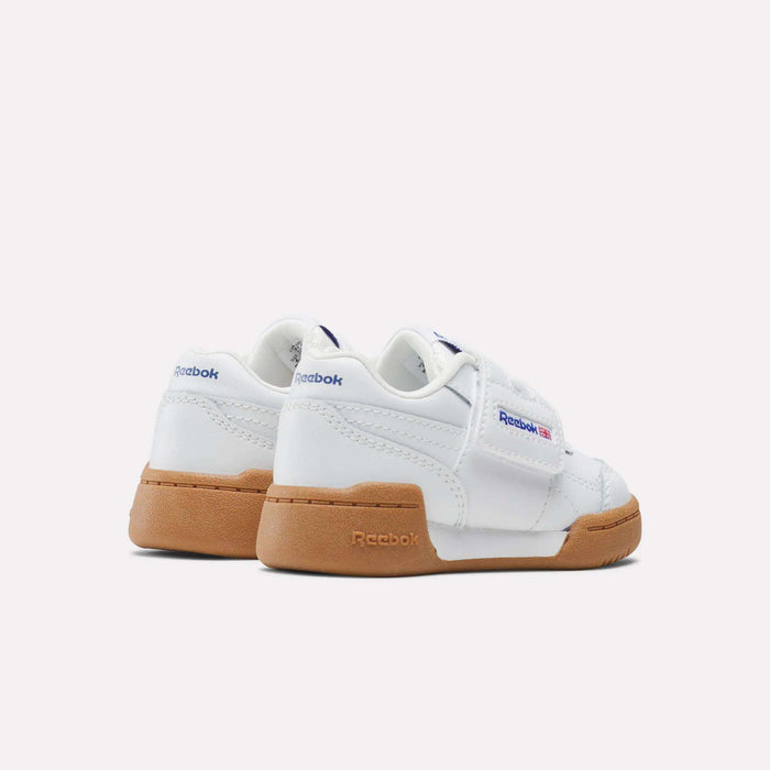 The Reebok Kids' Workout Plus Shoes for babies and toddlers are white with gum soles, shown from the back and side, and feature blue and red Reebok branding on the sides and heel.