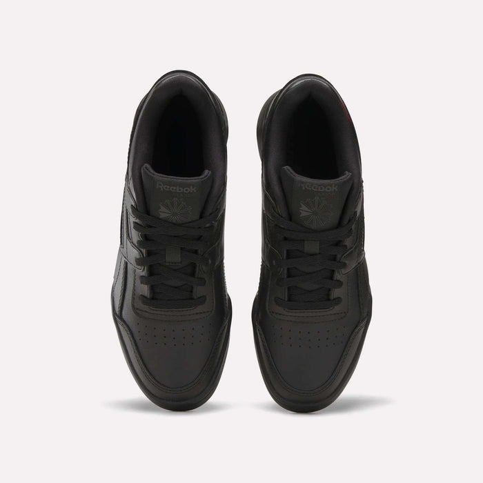 Top view of a pair of black Reebok Workout Plus Shoes for big kids with laces, displayed side by side on a white background. The Reebok logo appears on the tongue of each sneaker.
