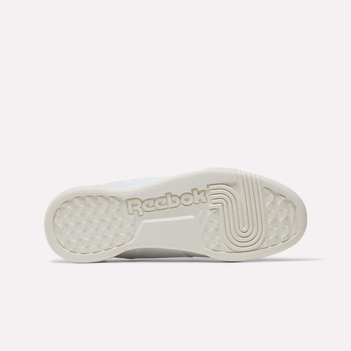 The image shows the sole of the Reebok Workout Plus Shoes - Big Kids, featuring the Reebok logo in the center, a textured circular pattern at the front, and a lined curved design near the heel for a sporty look.