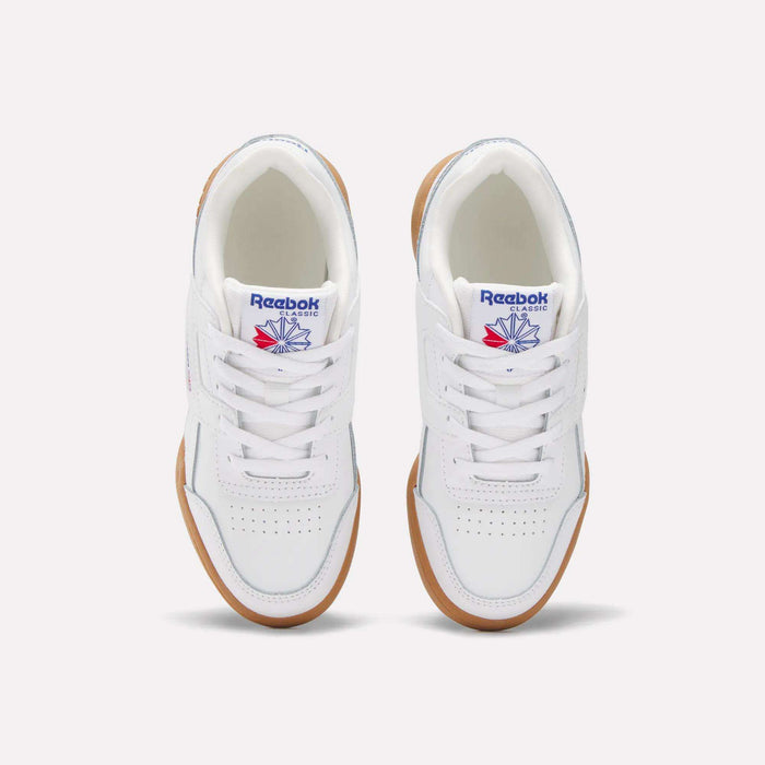A pair of white Reebok Workout Plus Shoes for little kids, seen from above. They have gum soles, white laces, toe perforations, and display the blue and red Reebok logo on the tongue.