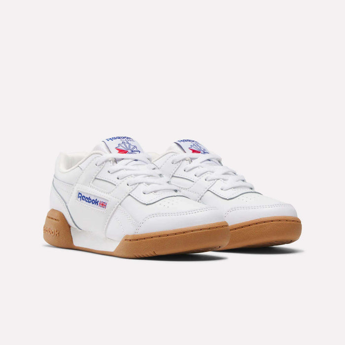 The Reebok Workout Plus Shoes for little kids are white with gum soles, blue and red Reebok logos on the tongue and sides, and white laces, shown against a plain light background.