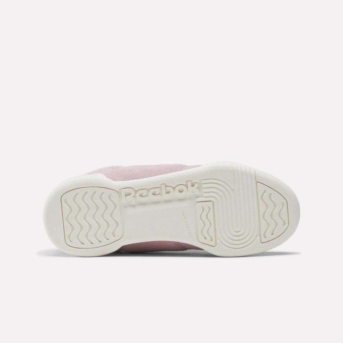 The image shows the sole of a pink and white Reebok Workout Plus Shoe for little kids, with the Reebok logo in the center and a textured grip pattern on the toe, heel, and sides.