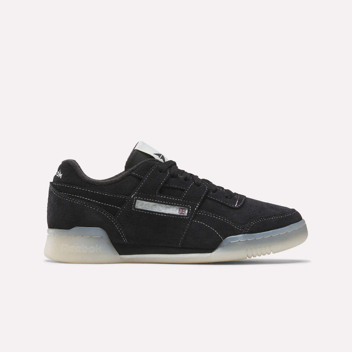 The Reebok Workout Plus Shoes feature a black design with white stitching, translucent off-white sole, and a small Union Jack logo on the side, capturing classic '80s fitness style against a plain white background.