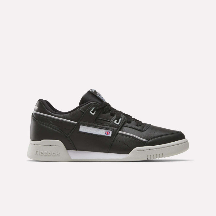 The Reebok Workout Plus Shoes are black leather low-tops with a white sole and subtle white and gray accents. Stylish for workouts, they display the Reebok logo and flag on the side.
