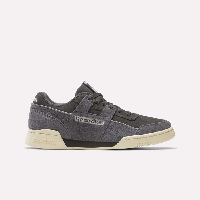 The Reebok Workout Plus Shoes in Black/Black/Paperwhite feature a vintage-inspired design with suede uppers, off-white soles, and classic Reebok branding on the side and heel, shown against a plain white background.