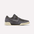 The Reebok Workout Plus Shoes in Black/Black/Paperwhite feature a vintage-inspired design with suede uppers, off-white soles, and classic Reebok branding on the side and heel, shown against a plain white background.