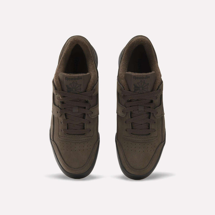 A pair of brown Reebok Workout Plus Shoes viewed from above, featuring laces, perforated toe boxes, and the Reebok logo on the tongues, set against a plain light background—these iconic Reebok sneakers effortlessly blend style and comfort.