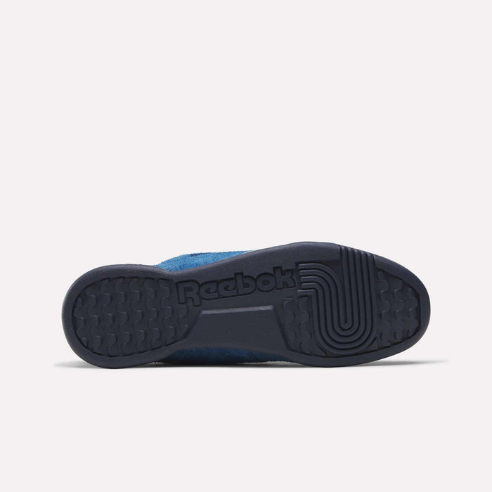 The image displays the sole of the Reebok Workout Plus Shoes in blue, seen from below, highlighting a textured tread pattern and the molded Reebok logo in the rubber.
