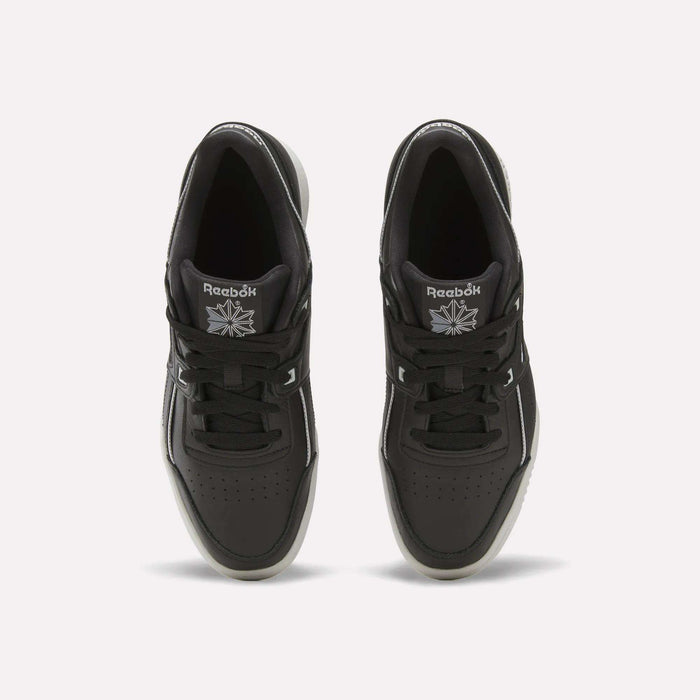 Top view of a pair of black Reebok Workout Plus Shoes with black laces, white accents, and the Reebok logo in white on each tongue. These sneakers are placed side by side on a plain white background.