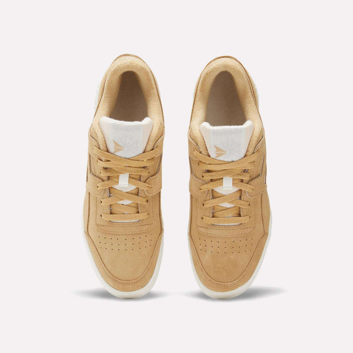 Top view of a pair of Reebok Workout Plus Shoes in tan suede with white midsoles and cream laces. The Reebok logo appears on the tongue, showcasing classic '80s fitness style against a light background.